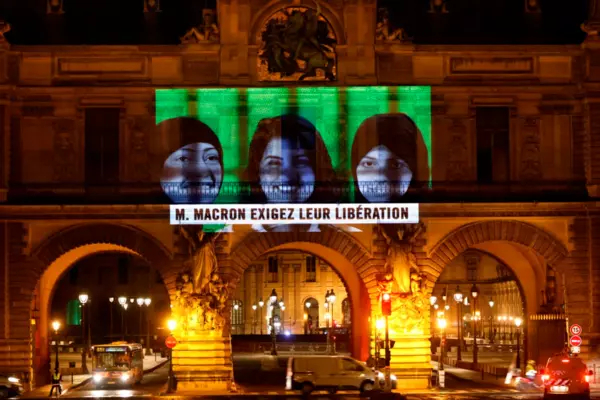 A projection on the Louvre Museum in Paris by Amnesty International depicts jailed Saudi human rights activists including Loujain Al-Athloul (C) and reads “Mr Macron, demand their release,” ahead of the virtual G20 summit in November 2020. Thomas Coex/AFP via Getty Images