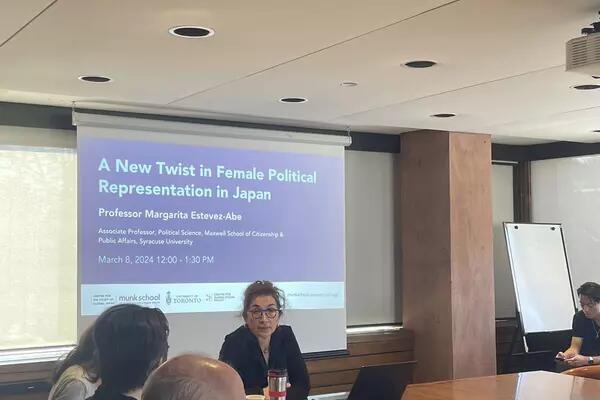 Woman sitting in front of powerpoint presentation that says "a new twist in female political representation in Japan"